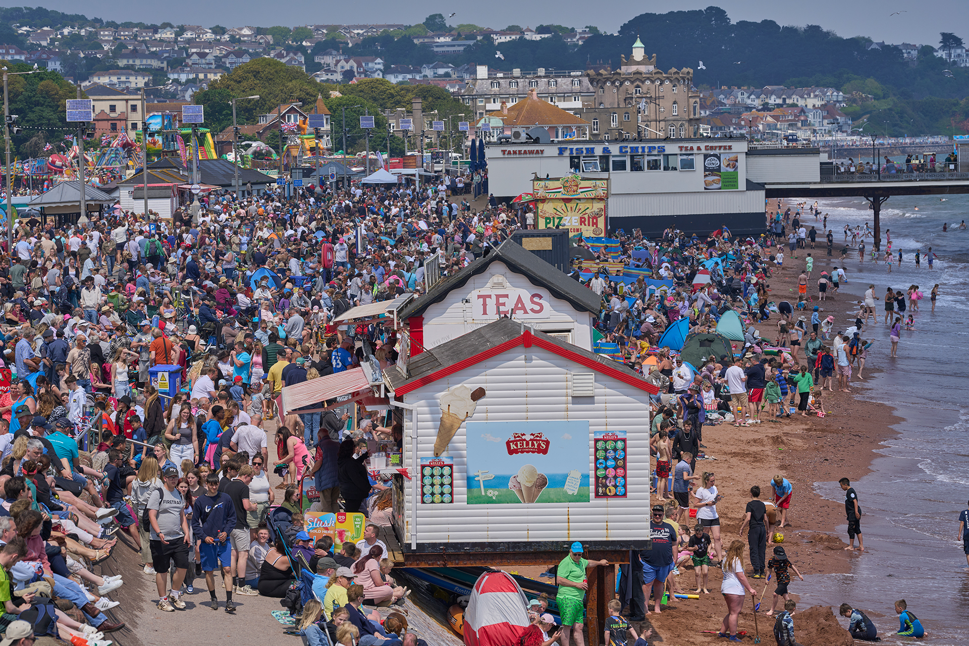 A very busy Paignton seafront with the tide coming in.