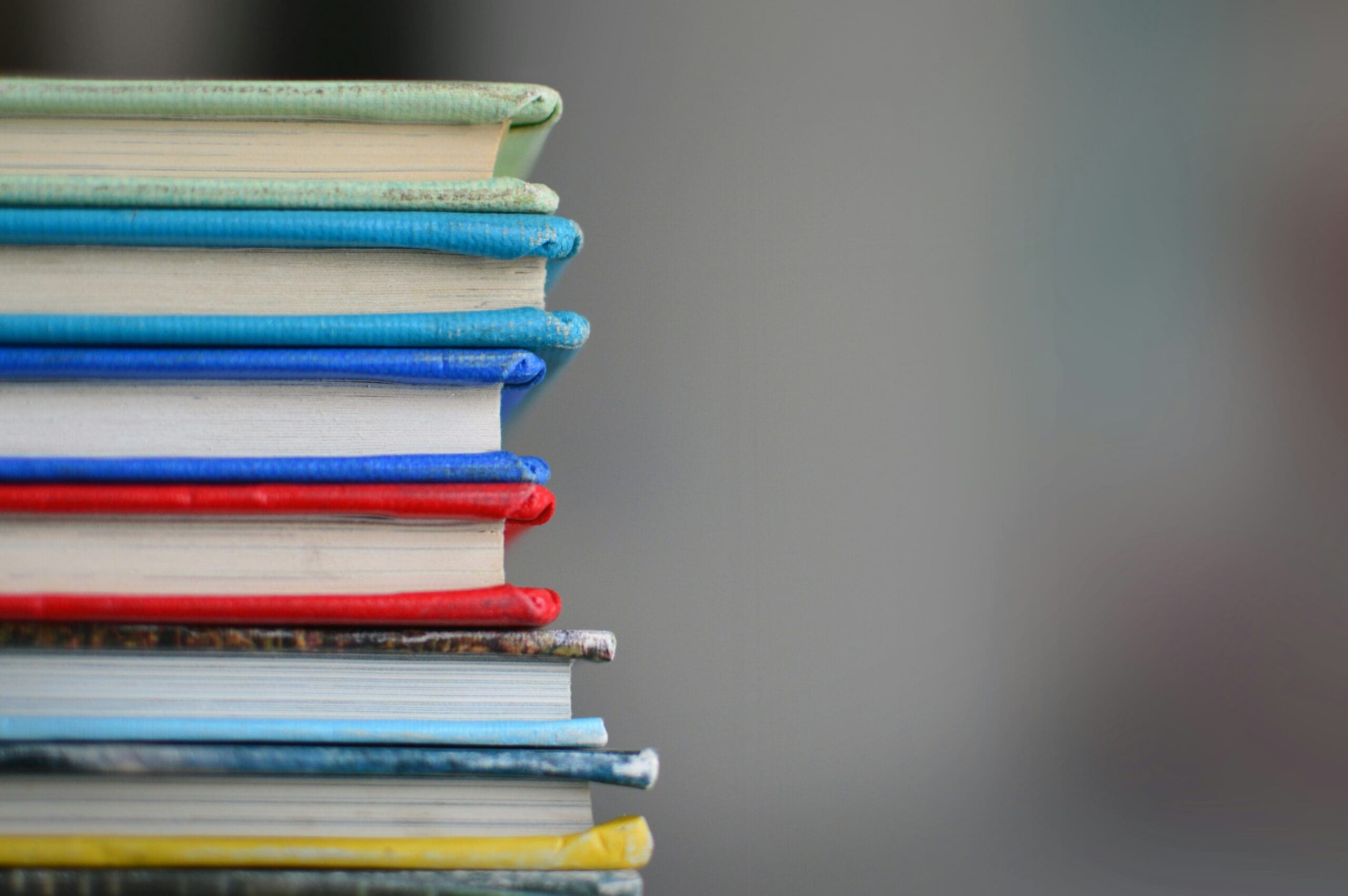 kimberly-farmer-lUaaKCUANVI-unsplash An image of text books piled up.