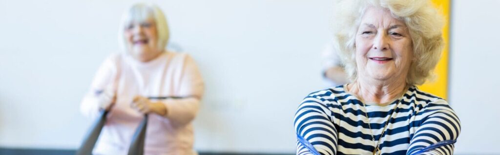 two women undertaking a fitness activity with bands