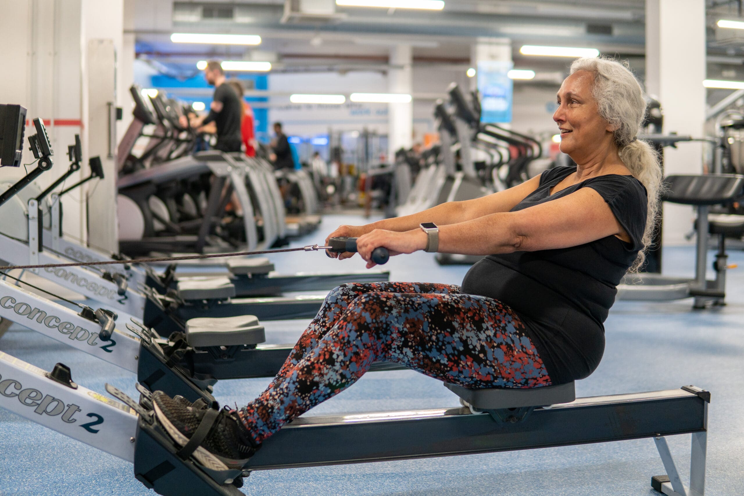 Older woman on a rowing machine in a gym environment
